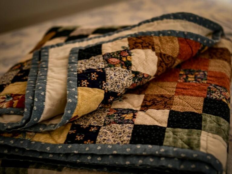 A folded patchwork quilt with brown, cream and black squares
